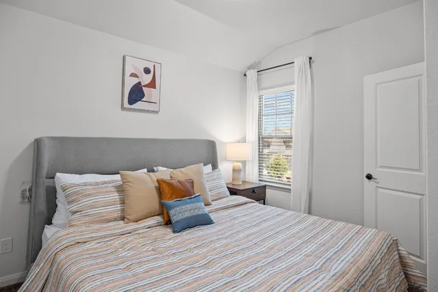 a bedroom with a bed and painting on the wall