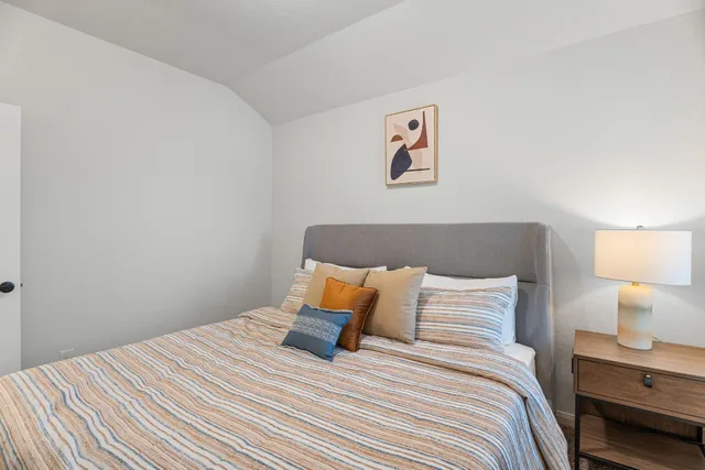 a bedroom with a bed and painting on the wall