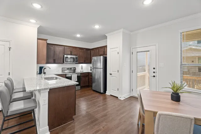 a kitchen with refrigerator and chairs