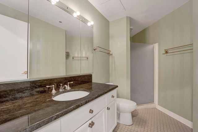 a bathroom with a granite countertop sink toilet and shower