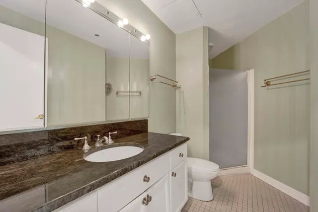 a bathroom with a granite countertop sink toilet and shower