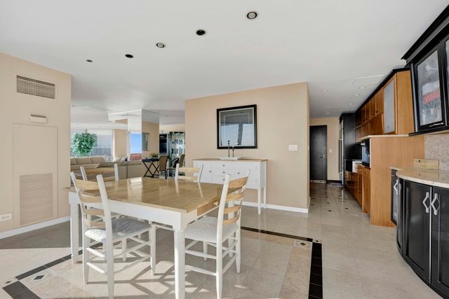 a dining room with furniture a fireplace and kitchen view