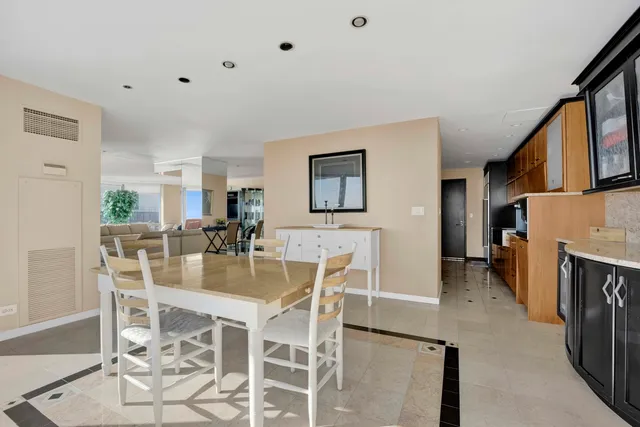 a dining room with furniture a fireplace and kitchen view