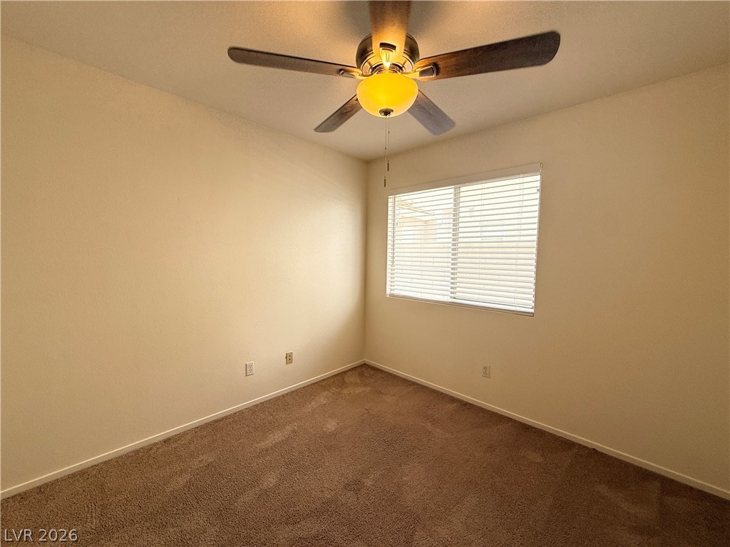 8870 Haviland Road Las Vegas, NV 89123 - Photo 13 of 24 A well-lit bedroom features plush carpeting and a convenient ceiling fan.