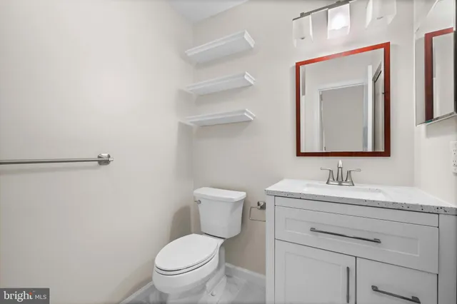 a bathroom with a toilet sink vanity and mirror
