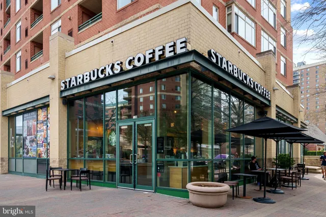 a group of people sitting in front of retail shop
