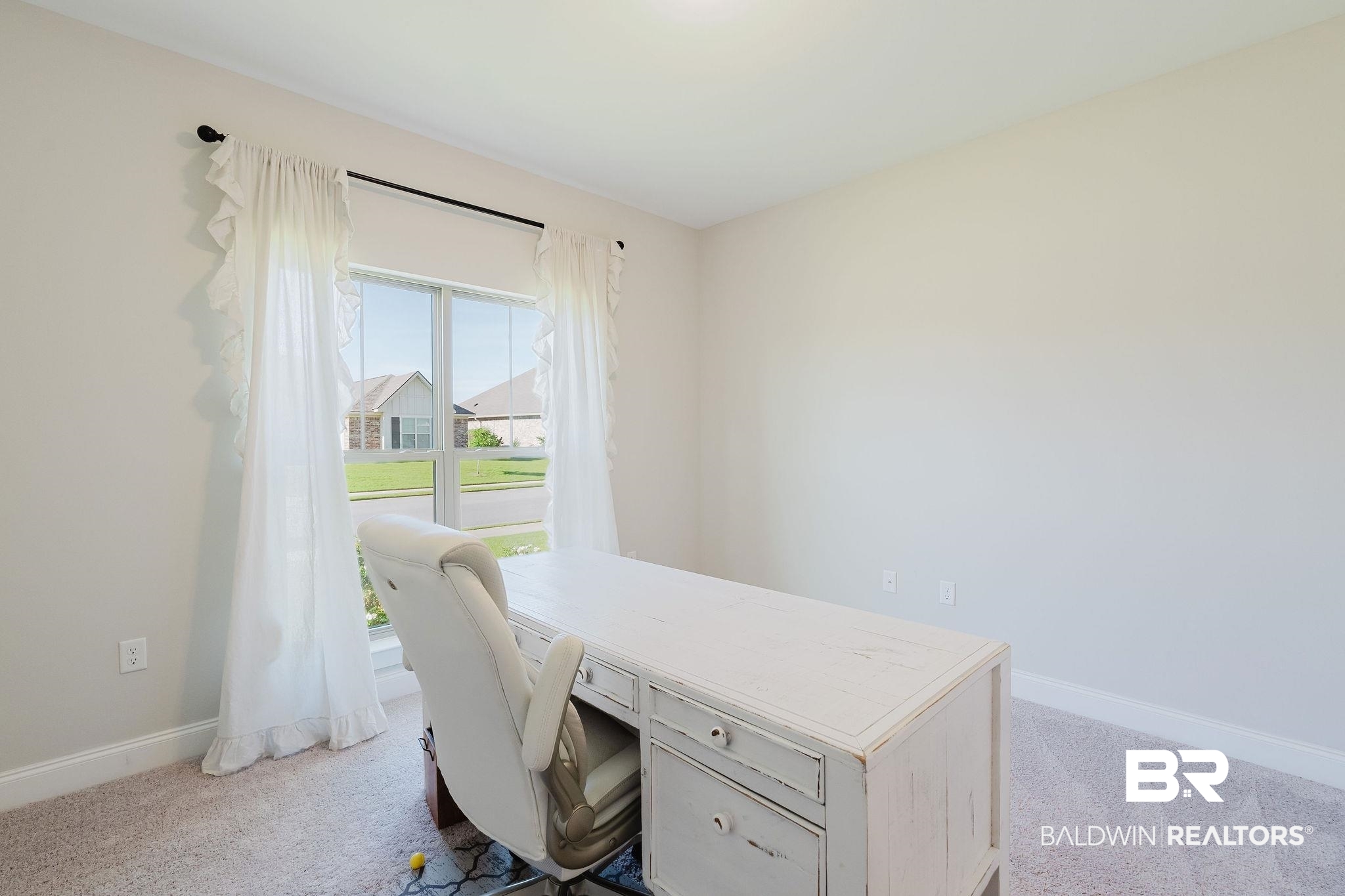 7872 Calverton Street Foley, AL 36535 - Photo 11 of 76 Bright room featuring neutral-toned walls, a single window with white sheer curtains, and light-colored carpeting