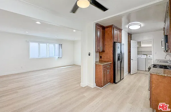 a kitchen with stainless steel appliances granite countertop a refrigerator and a stove top oven