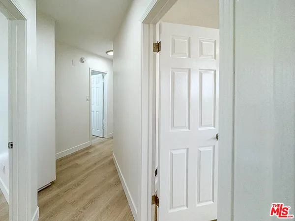 a view of a hallway with wooden floor