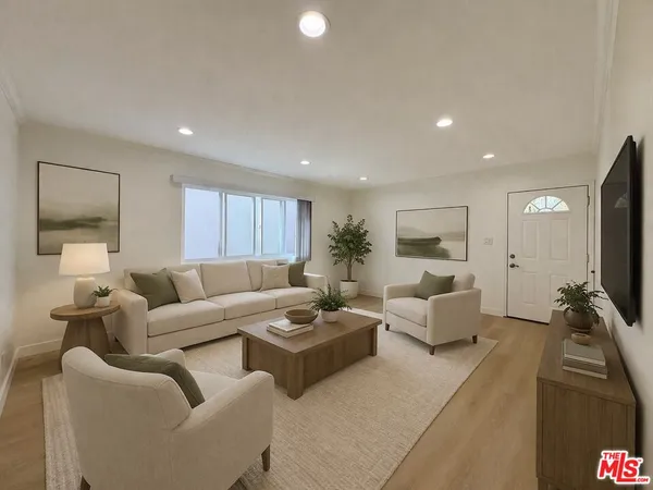 a living room with furniture flat screen tv and couches