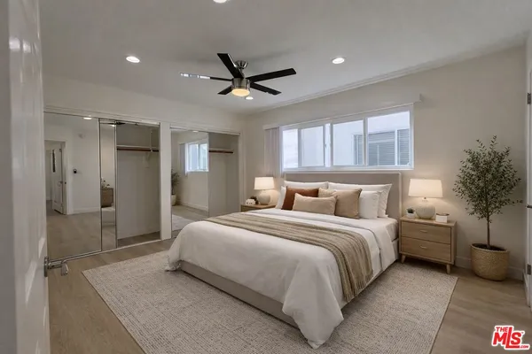 a bedroom with a bed and a potted plant