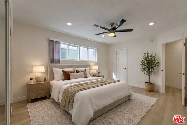 a bedroom with a bed and a potted plant