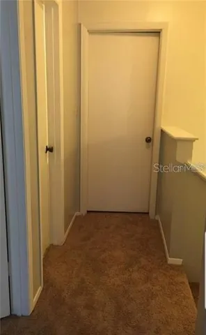 a view of a bathroom with a hallway and toilet