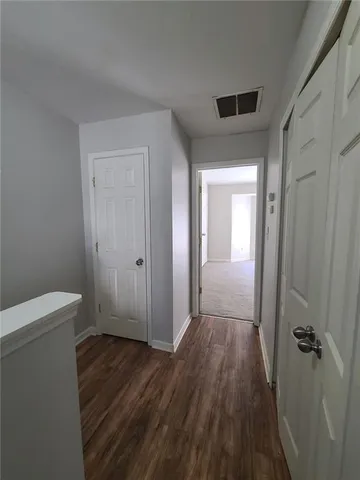 a view of a hallway with wooden floor