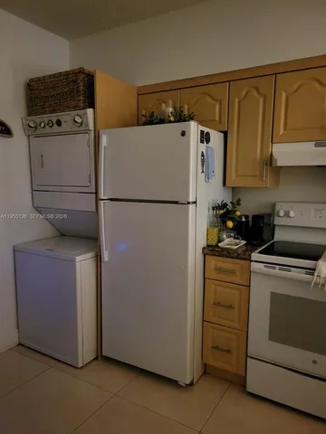 a white refrigerator freezer and a stove sitting inside of a kitchen