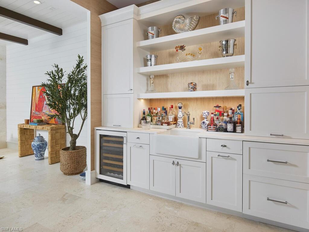 909 10th Avenue South Naples, FL 34102 - Photo 12 of 34 a kitchen with white cabinets and a potted plant
