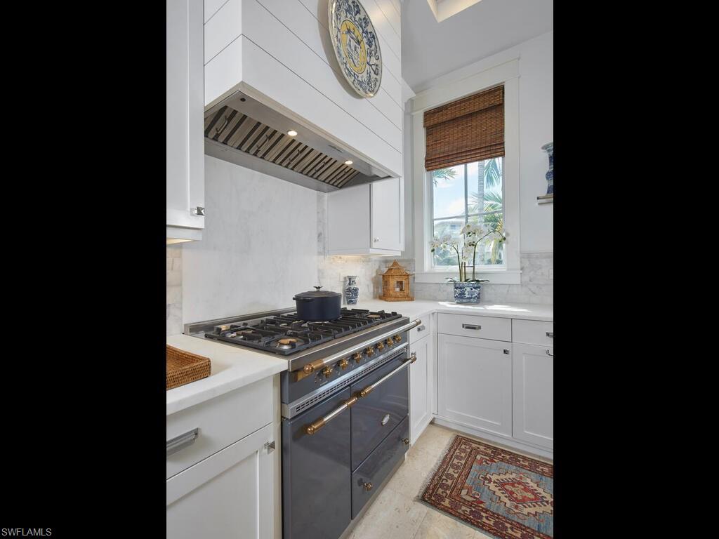 909 10th Avenue South Naples, FL 34102 - Photo 8 of 34 a kitchen with stainless steel appliances granite countertop a stove a sink and a microwave