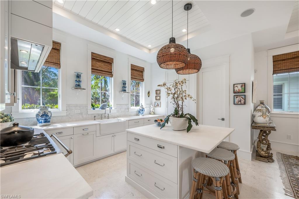 909 10th Avenue South Naples, FL 34102 - Photo 9 of 34 a kitchen with a sink a window and chairs