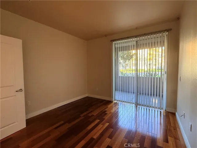 a view of a hallway with wooden floor and closet area