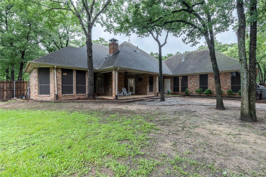 320 Rustic Oaks Road Combine, TX 75159 - Photo 11 of 40 Rear view of house with a patio, a shingled roof, a chimney, and brick siding