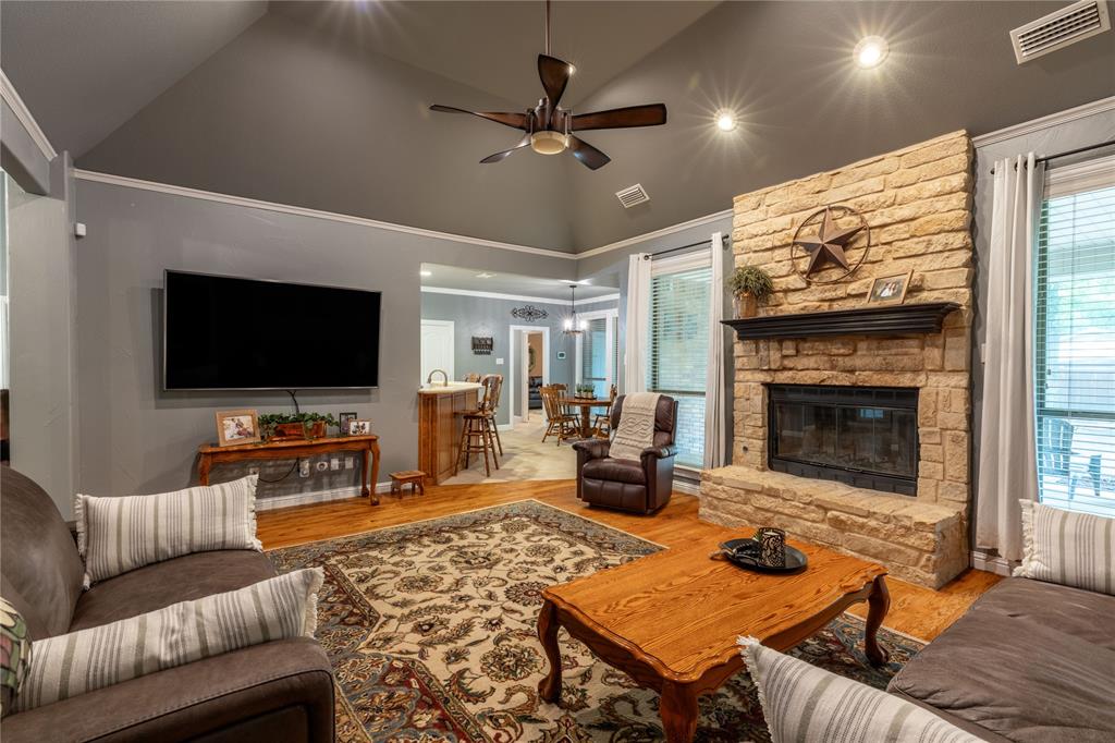 320 Rustic Oaks Road Combine, TX 75159 - Photo 13 of 40 Living area with a ceiling fan, wood finished floors, high vaulted ceiling, and a fireplace