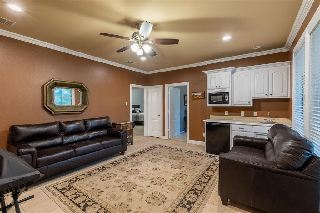 320 Rustic Oaks Road Combine, TX 75159 - Photo 19 of 40 Family room featuring sink, microwave, cabinets, mini fridge, ceiling fan,tile flooring, recessed lighting, ornamental molding