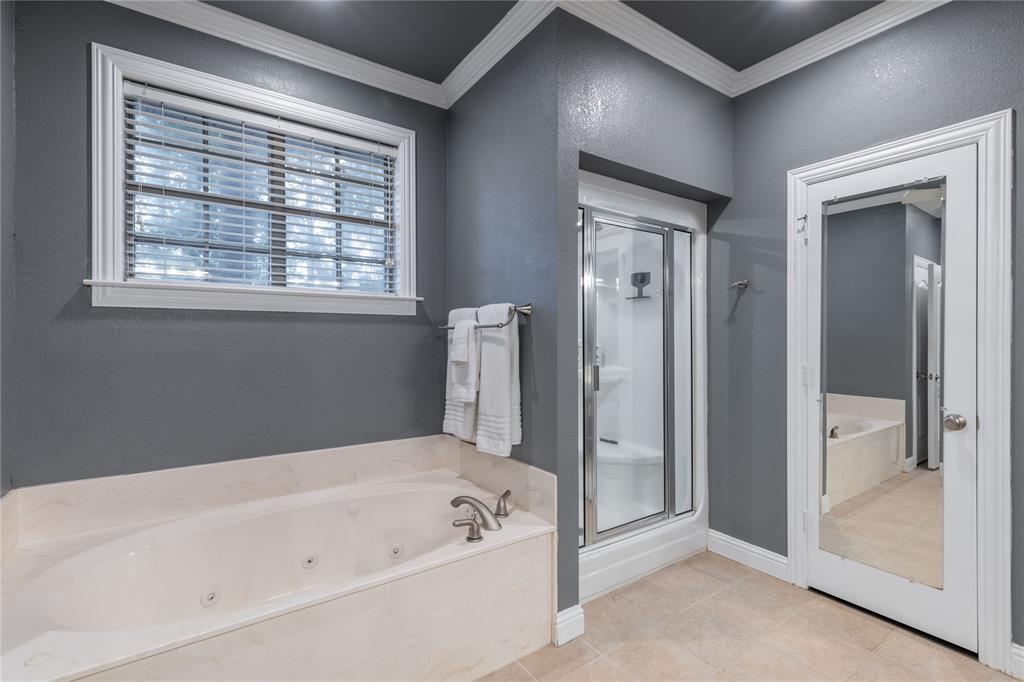 320 Rustic Oaks Road Combine, TX 75159 - Photo 20 of 40 Bathroom featuring a stall shower, a whirlpool tub, crown molding, and tile patterned flooring