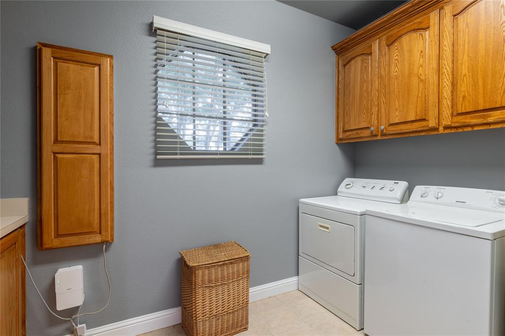320 Rustic Oaks Road Combine, TX 75159 - Photo 27 of 40 Laundry area featuring cabinet space, independent washer and dryer, sink and tile flooring
