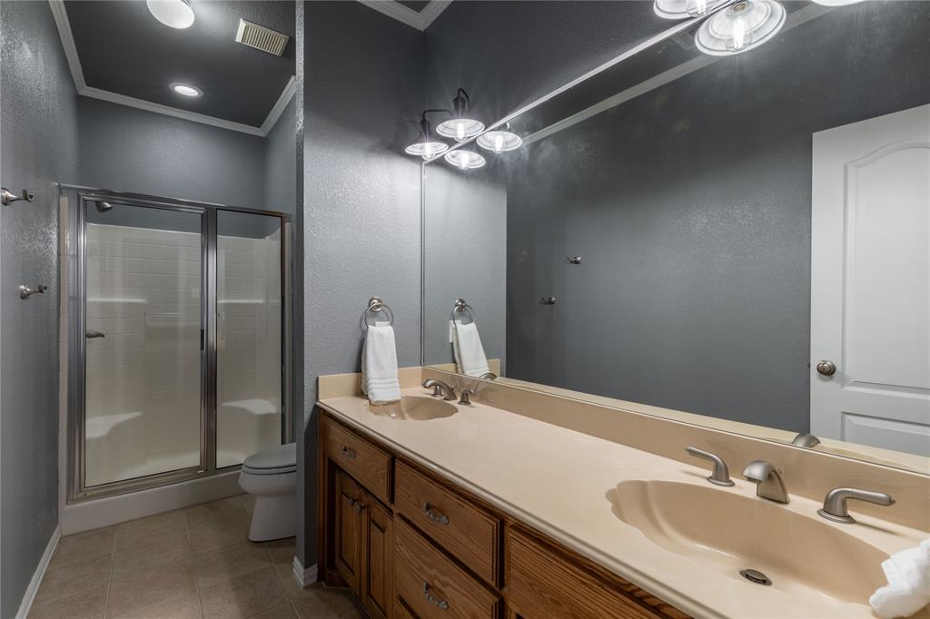 320 Rustic Oaks Road Combine, TX 75159 - Photo 30 of 40 Full bathroom with crown molding, a shower stall, double vanity, tile patterned floors, and a textured wall