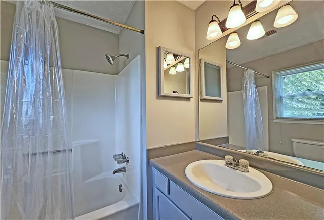 a bathroom with a sink a mirror and a shower