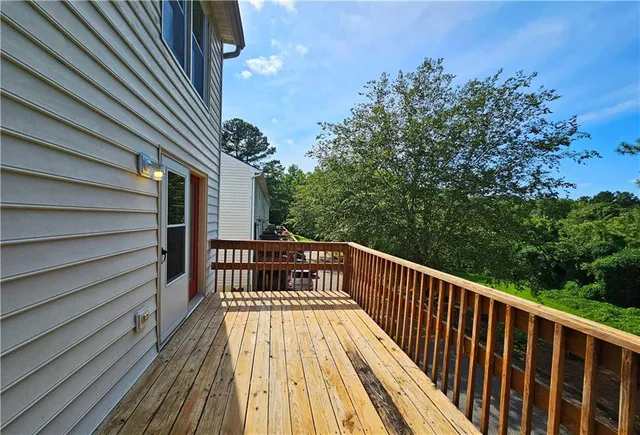 a view of balcony with wooden floor and fence and trees