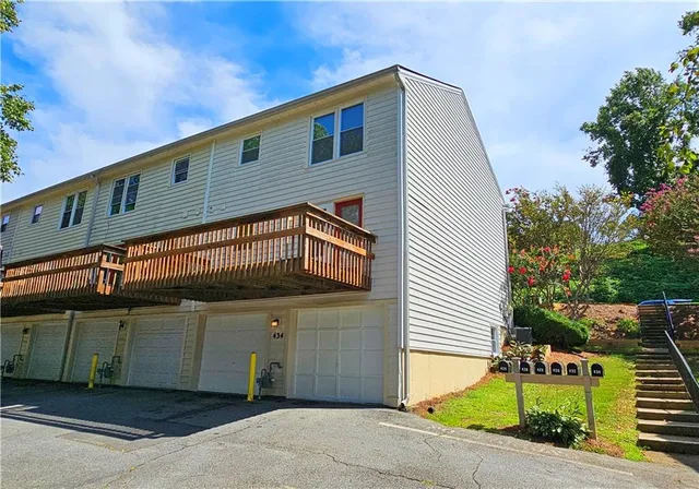 a front view of a house with a garden and parking