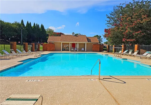 a view of a house with pool and chairs