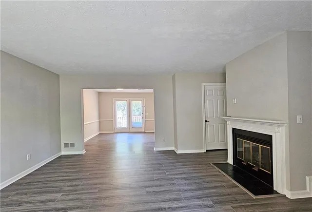 a view of empty room with wooden floor and fireplace