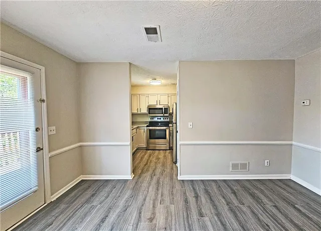 a view of a kitchen with wooden floor and electronic appliances