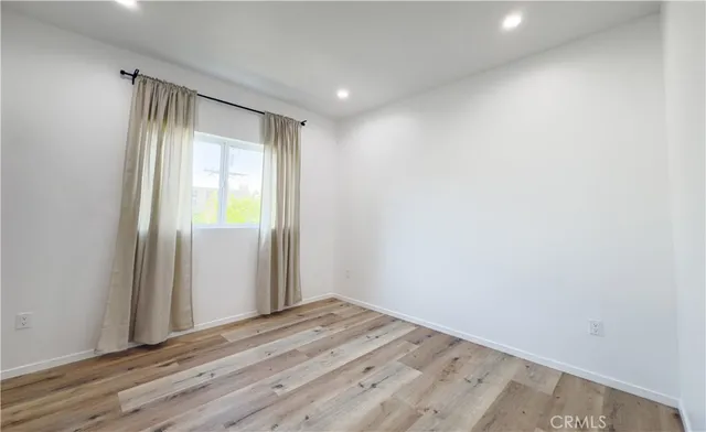 an empty room with wooden floor and a window
