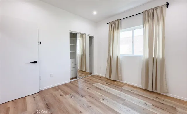 a view of a livingroom with wooden floor and closet area