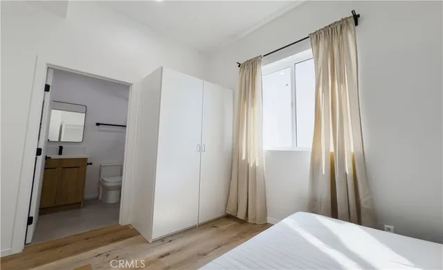 a bedroom with a bed and wooden floor