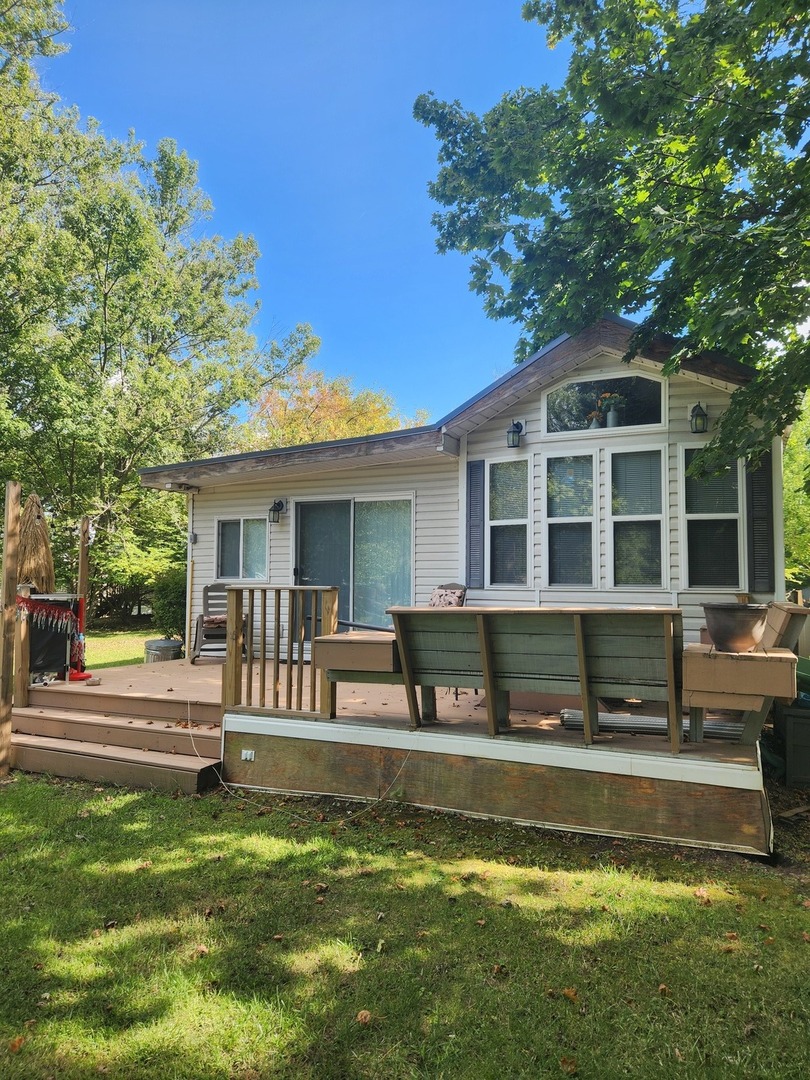 24-65 Woodhaven Lakes Sublette, IL 61367 - Photo 2 of 32 a front view of a house with a yard table and chairs