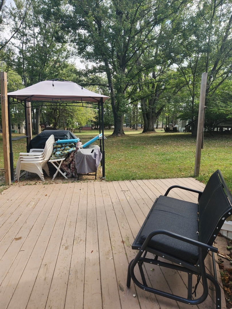 24-65 Woodhaven Lakes Sublette, IL 61367 - Photo 9 of 32 a view of a patio with lawn chairs under an umbrella