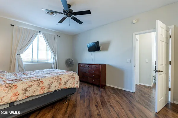 a bedroom with a bed a flat screen tv and a window