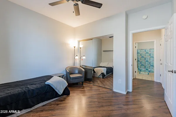 a bedroom with a bed and wooden floor