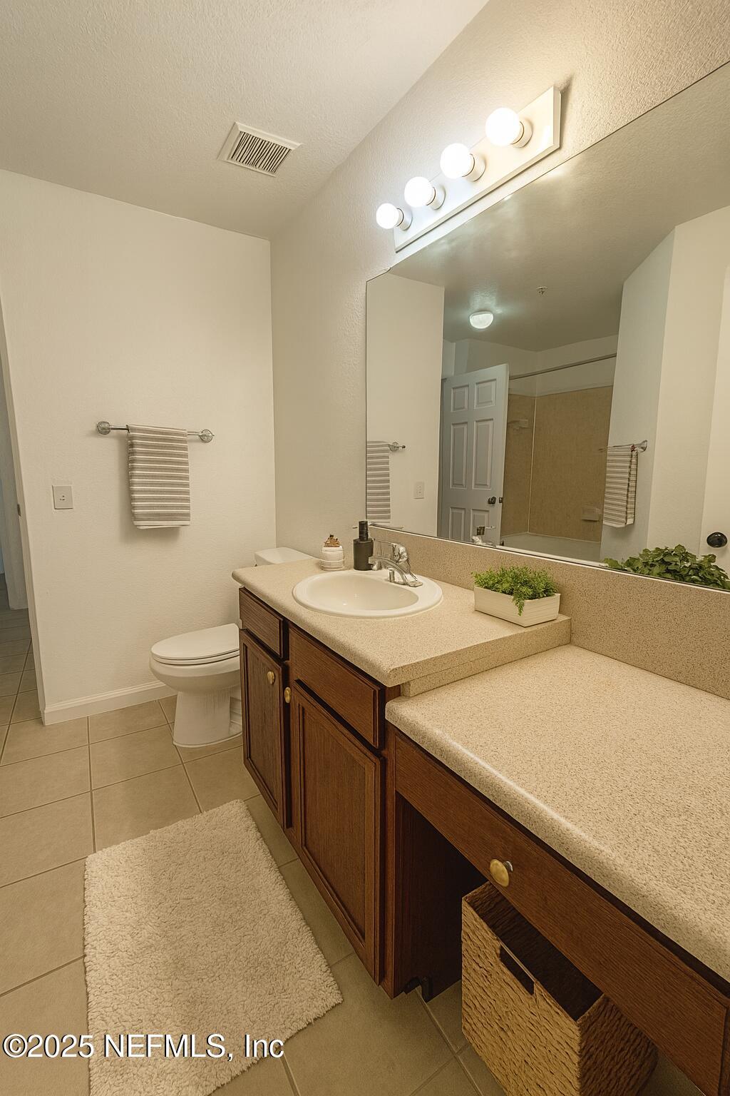 8550 Touchton Road, Unit 922 Jacksonville, FL 32216 - Photo 14 of 41 a bathroom with a sink a toilet and a mirror