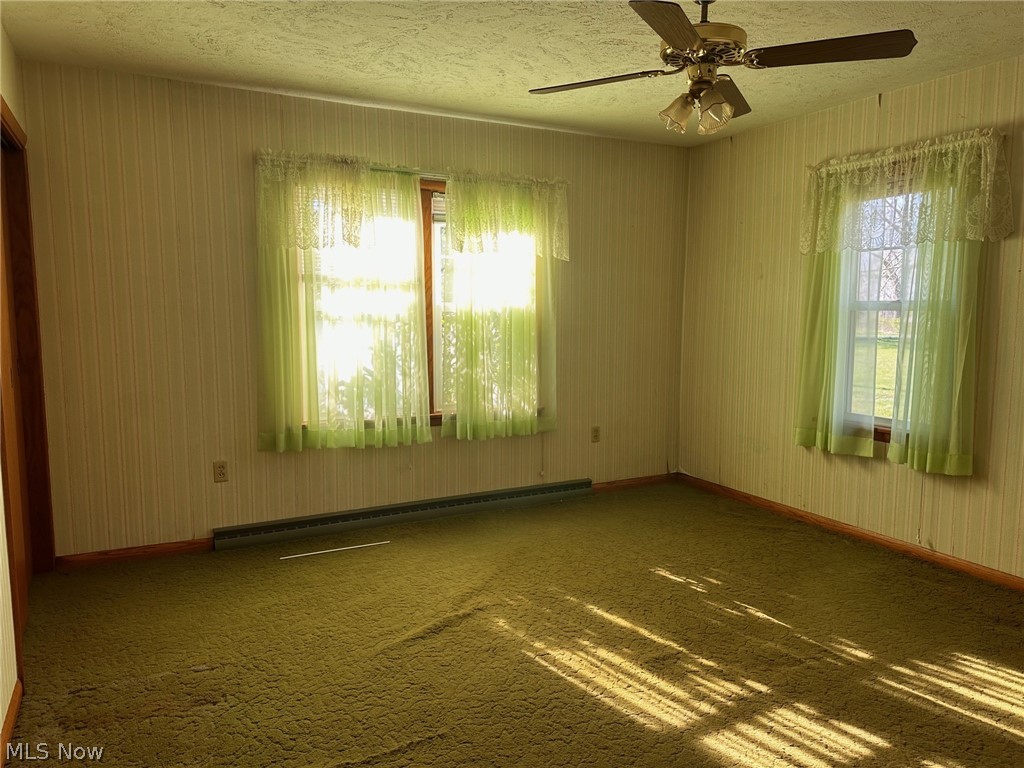 9526 Horn Road Windham, OH 44288 - Photo 9 of 14 Carpeted bedroom room with ceiling fan, baseboard heating, and a textured ceiling and tow large closets