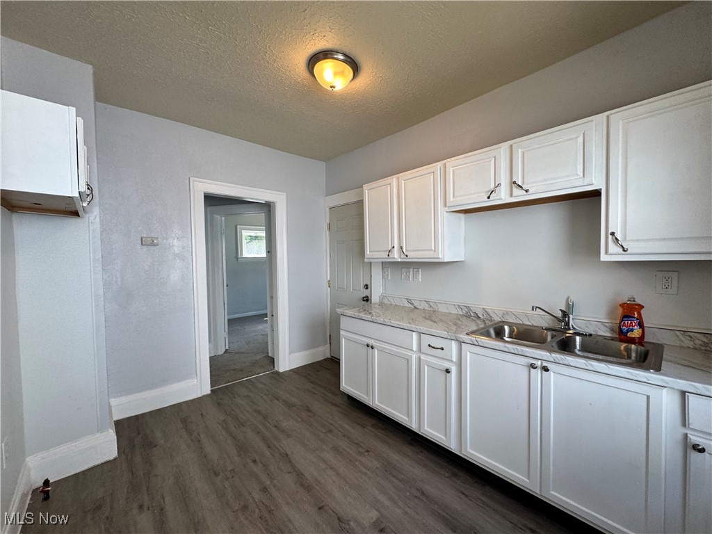 3624 East 118th Street Cleveland, OH 44105 - Photo 13 of 49 Kitchen with a textured ceiling, white cabinetry, light countertops, and dark wood-type flooring