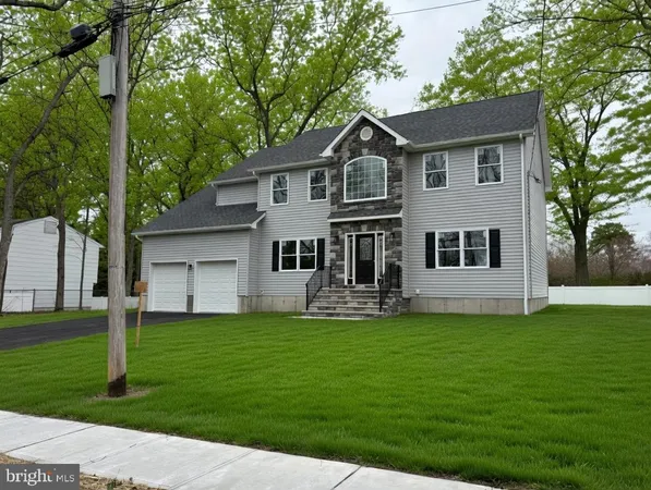 a front view of a house with a yard and trees