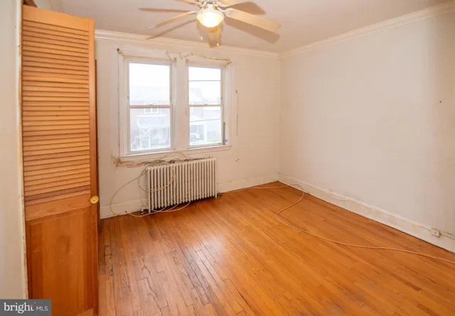 a view of an empty room with wooden floor