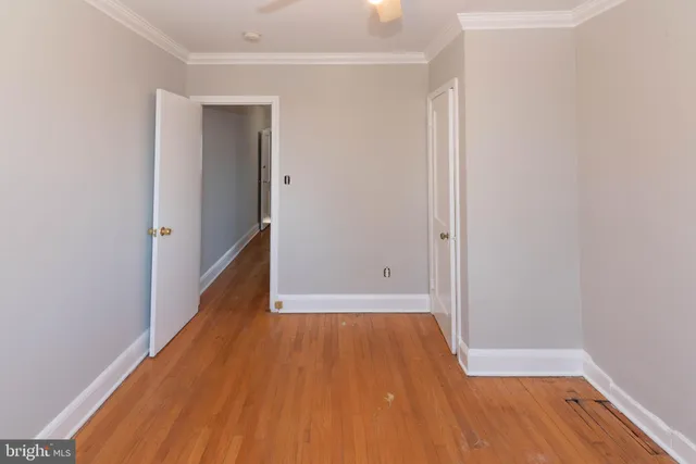 an empty room with wooden floor and entryway