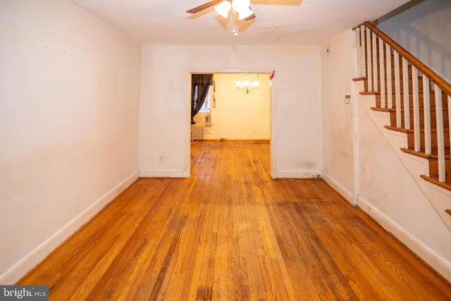 a view of a room with wooden floor and a chandelier