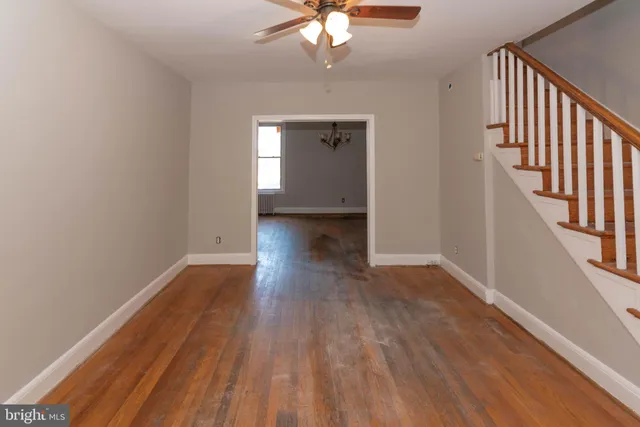 a view of a livingroom with wooden floor and a ceiling fan